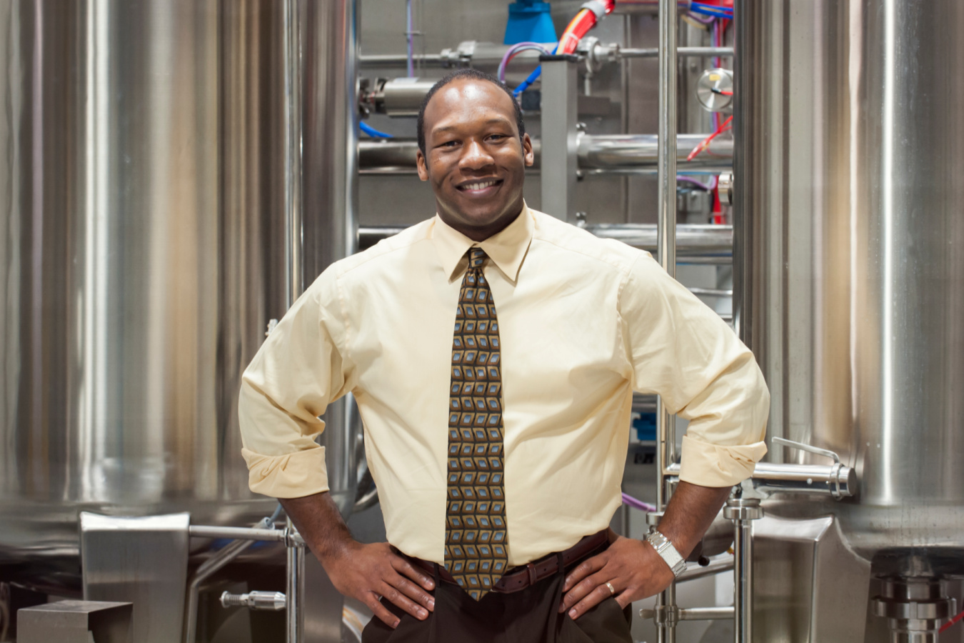 smiling manager standing by production tanks